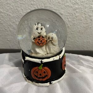 Glass snow globe decoration for Christmas or Halloween with pumpkins